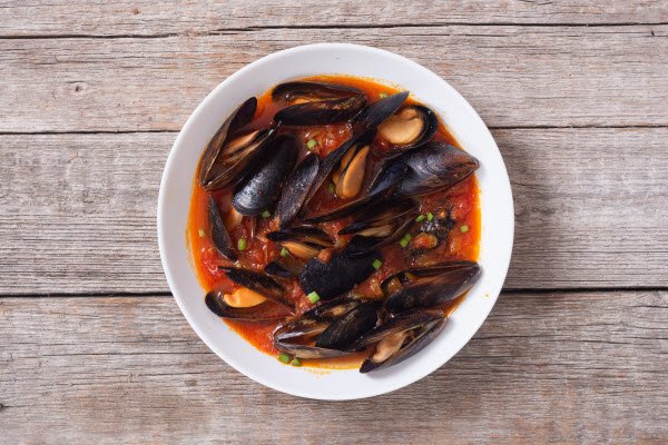 Boston Bay Mussel Bouillabaisse served in a white bowl.