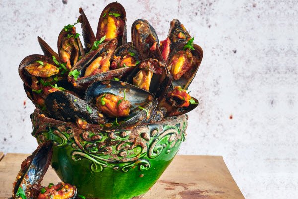 Boston Bay Mussels Marinara, served in a large ornate green ceramic bowl.