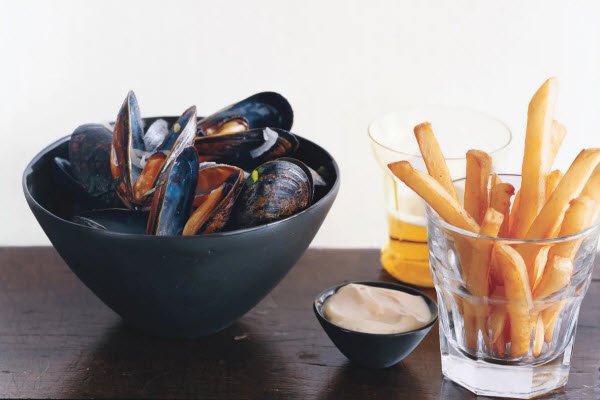French-style Mussels served in a black bowl, with Fries and Mustard Mayonnaise served to the side.