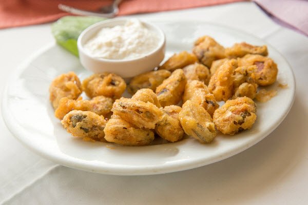 Greek Style Fried Mussels with Yoghurt Sauce, served on a white plate.